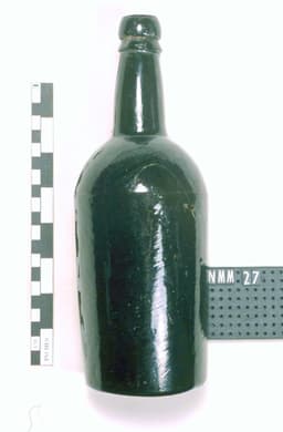 An old bottle made roughly with dark green glass.