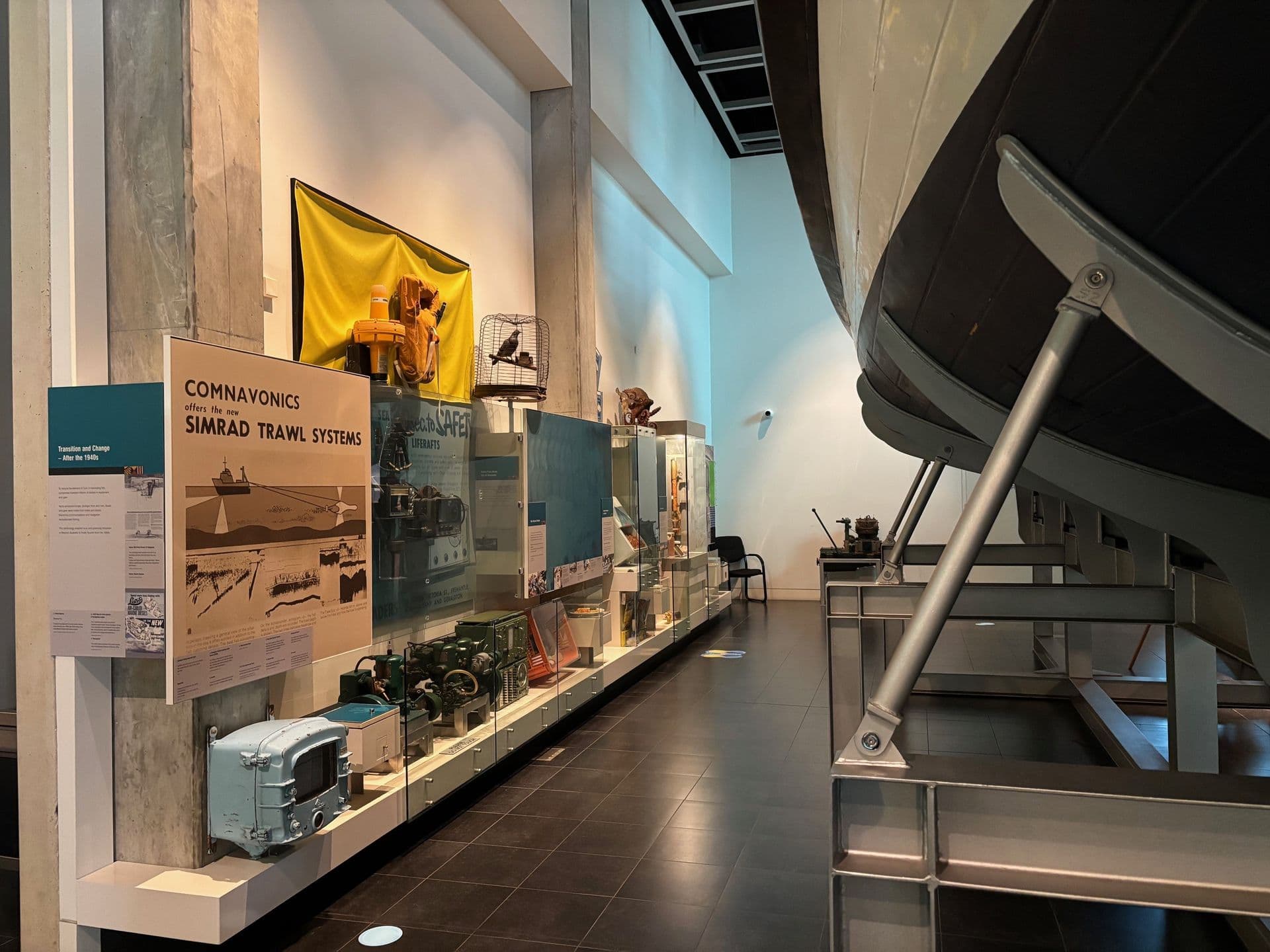 a display wall featuring assorted fishing industry items, including life jacket, fishing crates, and model seafood.
