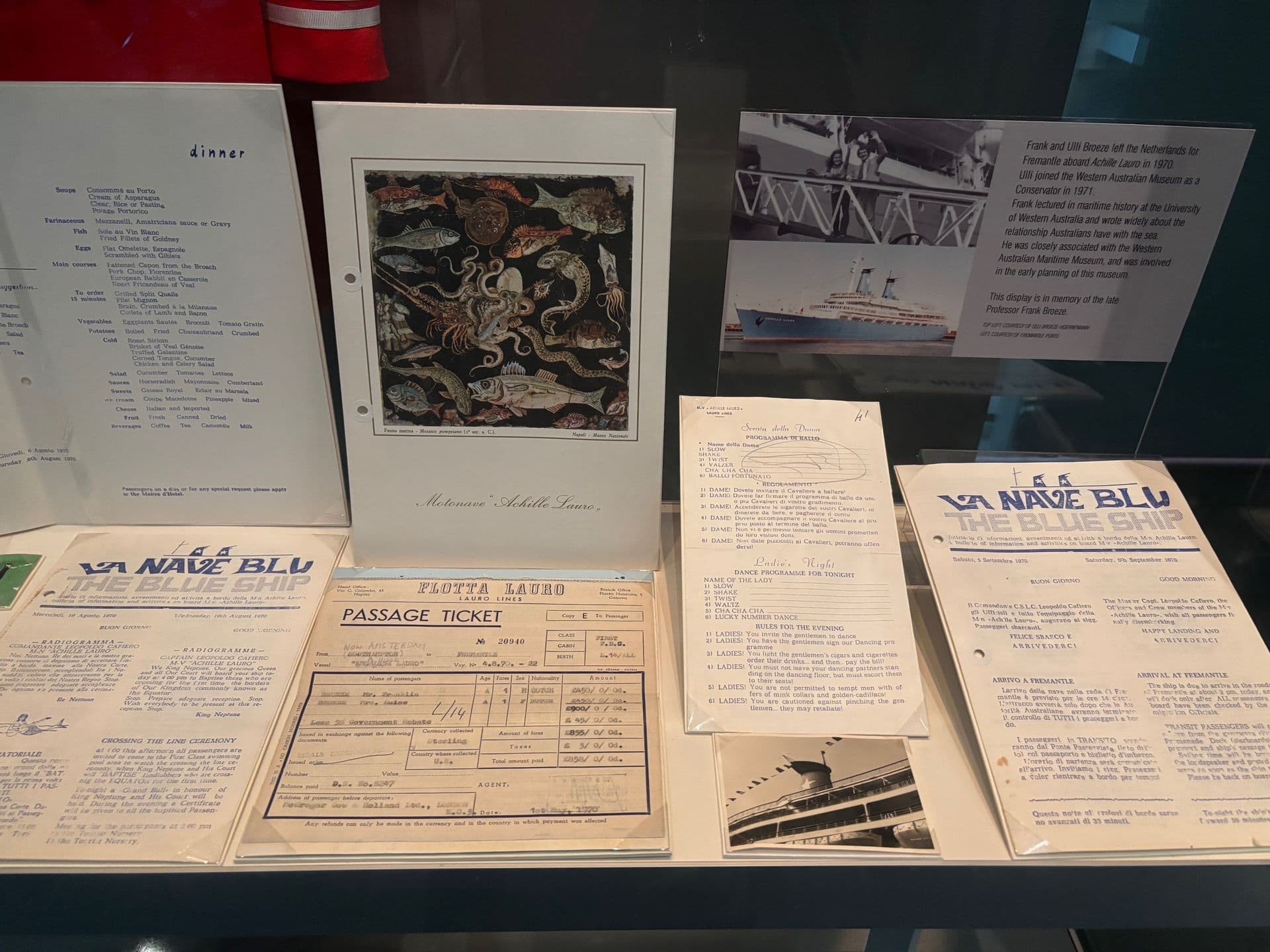 Original menu, passage ticket and newsletter from aboard Achille Lauro ship. They are on white paper printed with blue.