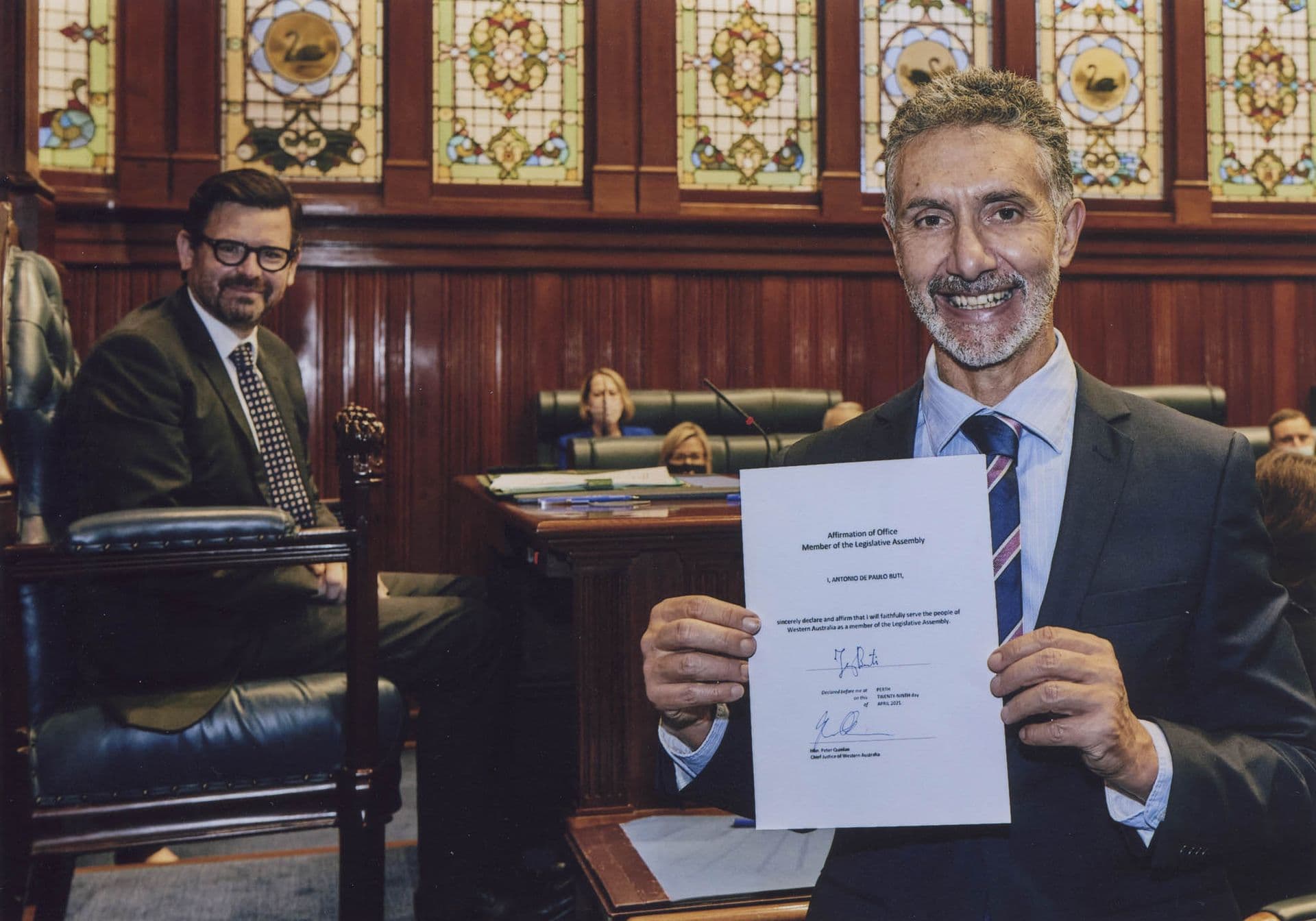 Tony smiling and holding up his Affirmation of Office.