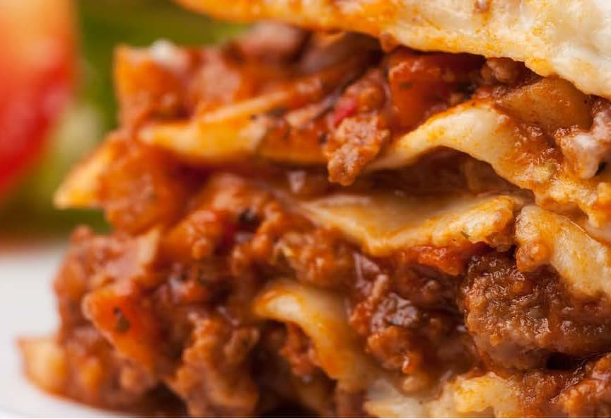 Layers of moist beef mince visible between sheets of pasta