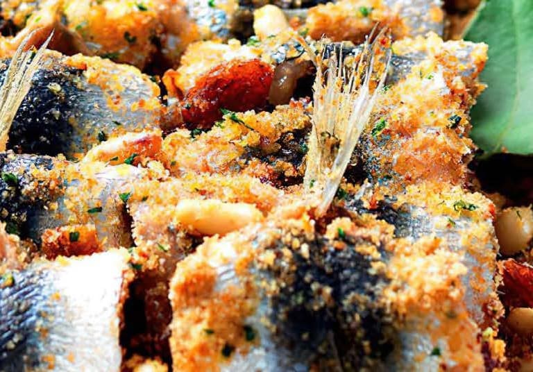 Sardine tail visible amongst rolled sardine fillets sprinkled in breadcrumbs